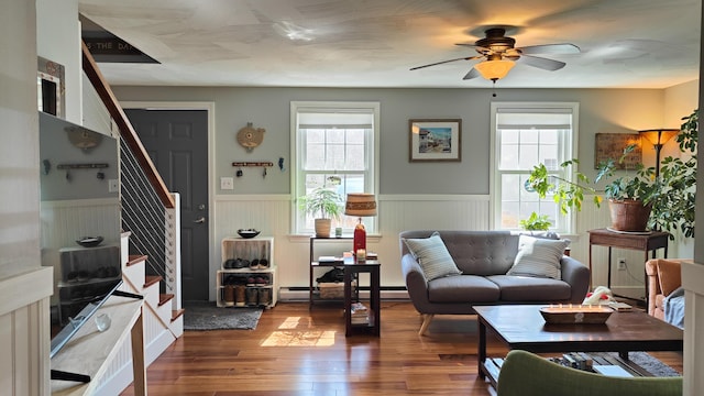 54 Black Smith Rd Unit 13, Wells, ME 04090 - living area featuring a ceiling fan, baseboard heating, wainscoting, stairway, and wood-type flooring