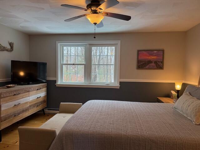54 Black Smith Rd Unit 13, Wells, ME 04090 - bedroom featuring a ceiling fan, wood finished floors, and baseboard heating