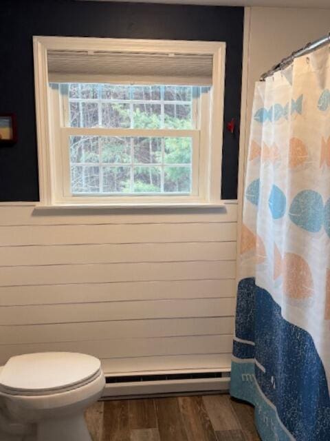 54 Black Smith Rd Unit 13, Wells, ME 04090 - full bathroom with wood finished floors, a baseboard radiator, curtained shower, and a wealth of natural light