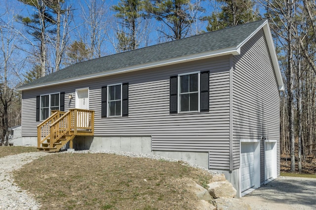 view of front of house with an attached garage, aphalt driveway, and roof with shingles