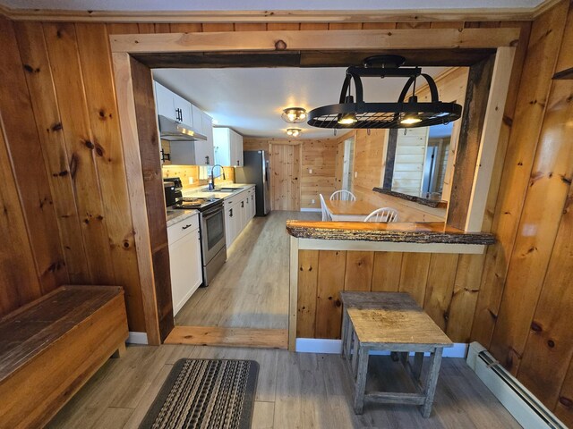 1898 Roxbury Rd, Roxbury, ME 04275 - kitchen featuring stainless steel appliances, a baseboard heating unit, a sink, light wood finished floors, and wood walls