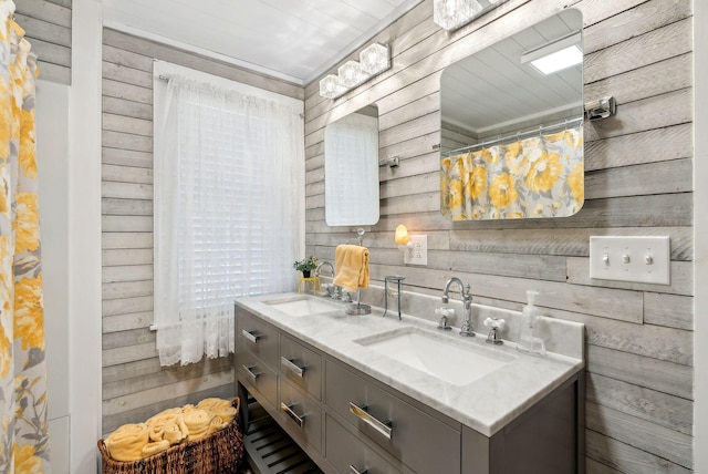 bathroom featuring double vanity, a sink, and wood walls