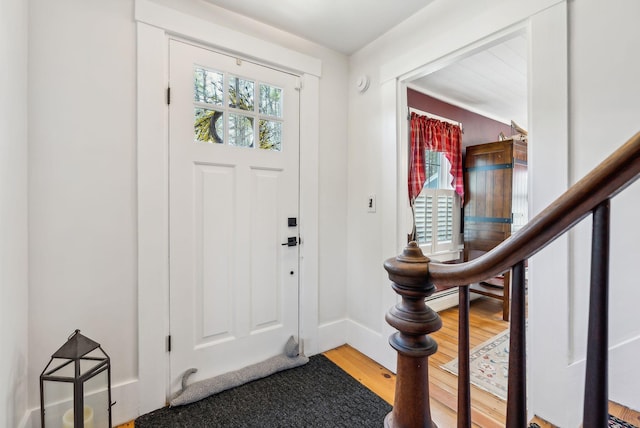 foyer with baseboards, wood finished floors, a wealth of natural light, and stairway