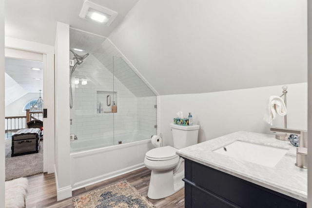 ensuite bathroom with wood finished floors, vanity, toilet, lofted ceiling, and enclosed tub / shower combo