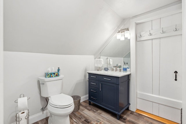 bathroom with toilet, wood finished floors, and lofted ceiling