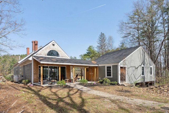 back of house featuring a chimney