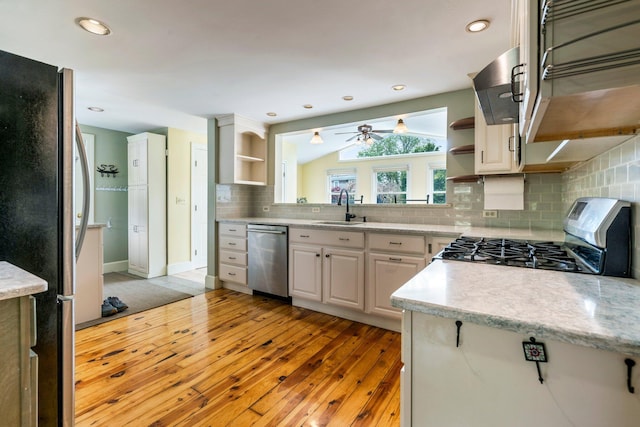 9 Phillips Rd, Falmouth, ME 04105 - kitchen with open shelves, stainless steel appliances, a sink, light wood finished floors, and backsplash