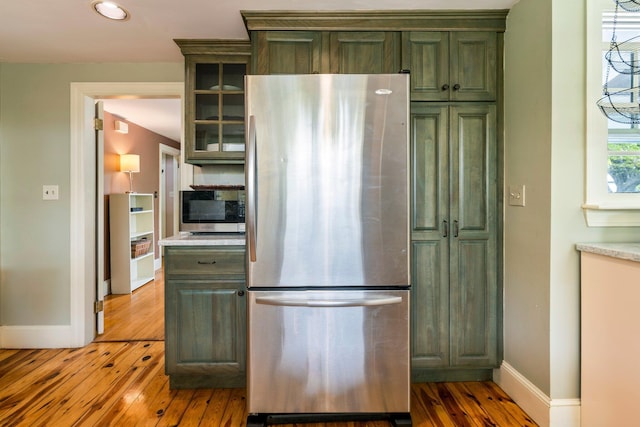 9 Phillips Rd, Falmouth, ME 04105 - kitchen featuring stainless steel appliances, green cabinets, baseboards, wood-type flooring, and light countertops
