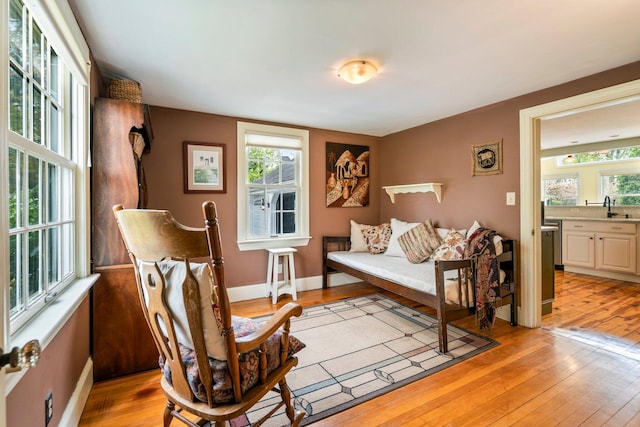 9 Phillips Rd, Falmouth, ME 04105 - bedroom with light wood-style flooring, ensuite bath, a sink, and baseboards