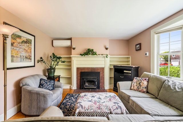 9 Phillips Rd, Falmouth, ME 04105 - living area featuring an AC wall unit, wood finished floors, baseboards, and a fireplace