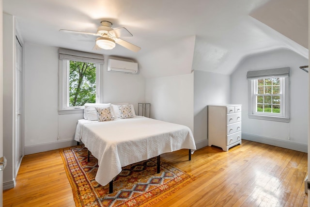 9 Phillips Rd, Falmouth, ME 04105 - bedroom with multiple windows, light wood finished floors, a wall mounted AC, lofted ceiling, and baseboards