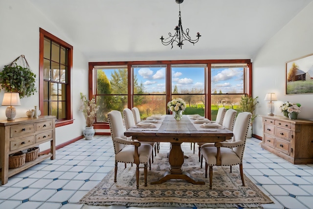 dining area with baseboards, vaulted ceiling, an inviting chandelier, and light floors