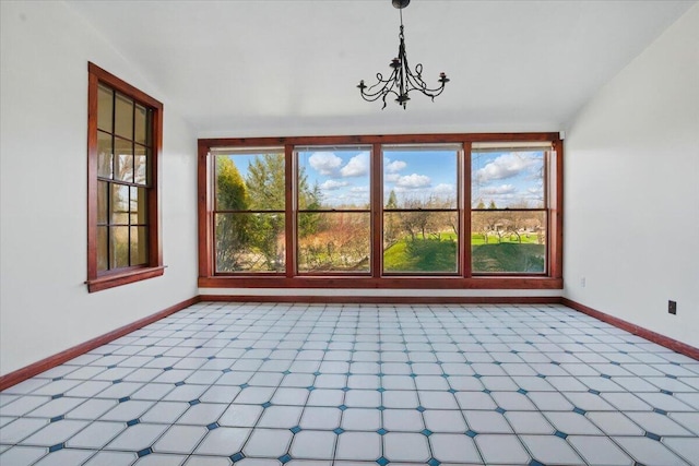 unfurnished dining area with baseboards and an inviting chandelier