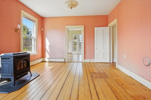 interior space featuring plenty of natural light, a wood stove, and hardwood / wood-style floors