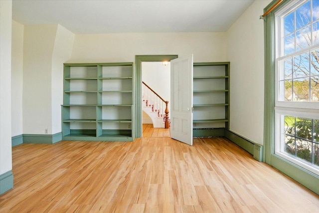 interior space with stairs, a healthy amount of sunlight, and wood finished floors