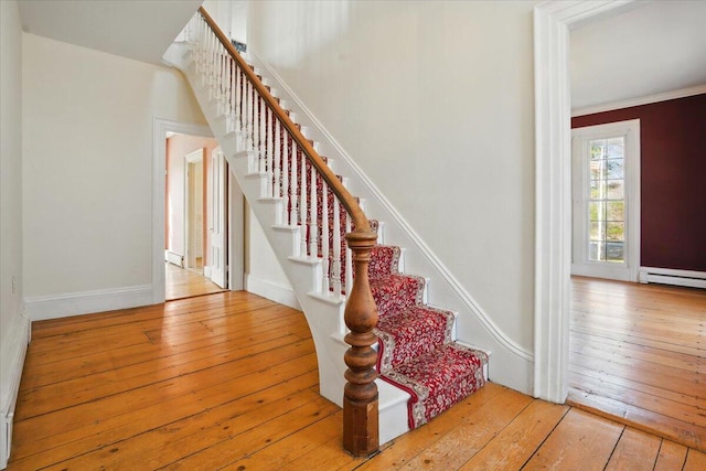 stairway with crown molding, baseboards, and hardwood / wood-style flooring