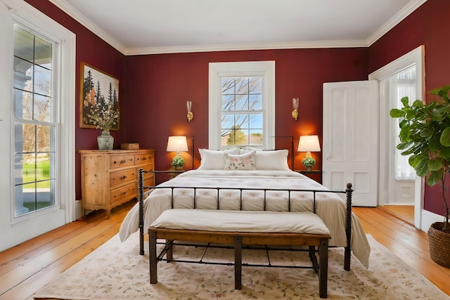 bedroom featuring crown molding and light wood finished floors