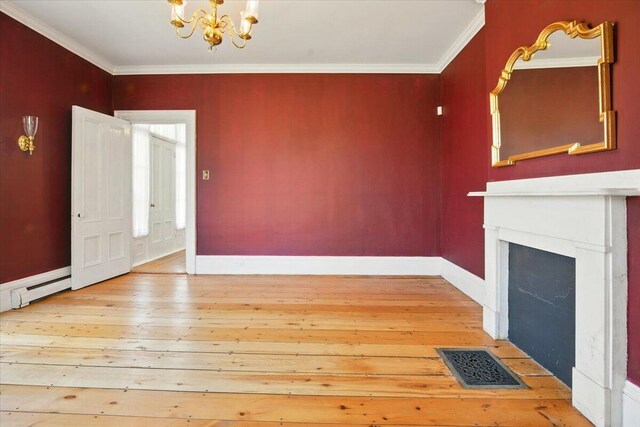 unfurnished living room with crown molding, an inviting chandelier, light wood finished floors, baseboards, and visible vents
