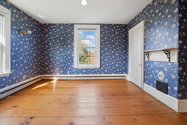 spare room featuring baseboards and hardwood / wood-style floors