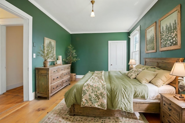 bedroom featuring crown molding, baseboards, and light wood-style floors