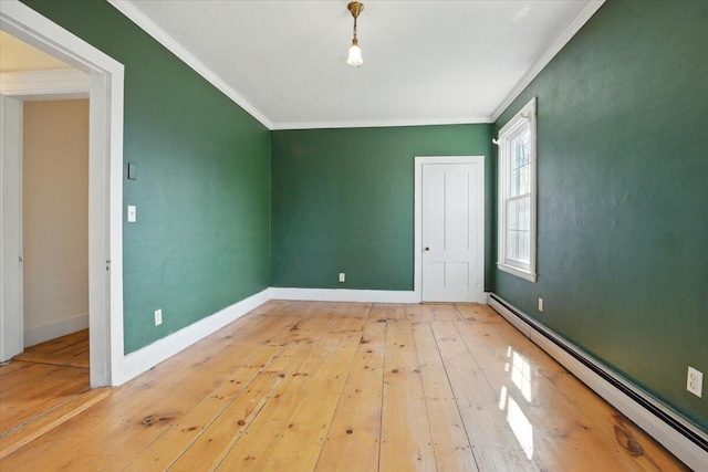 empty room with crown molding, baseboards, hardwood / wood-style flooring, and a baseboard radiator