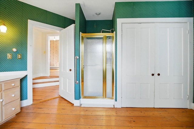 unfurnished bedroom featuring a closet, wallpapered walls, and hardwood / wood-style floors