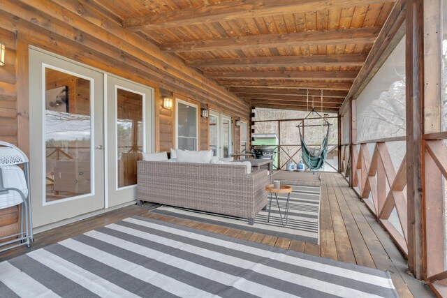 sunroom featuring beamed ceiling and french doors