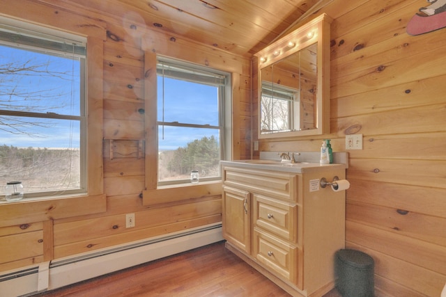 bathroom featuring wooden walls, wood finished floors, vanity, wooden ceiling, and a baseboard radiator
