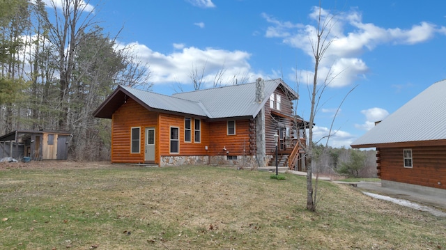 view of home's exterior with a lawn, an outbuilding, and metal roof
