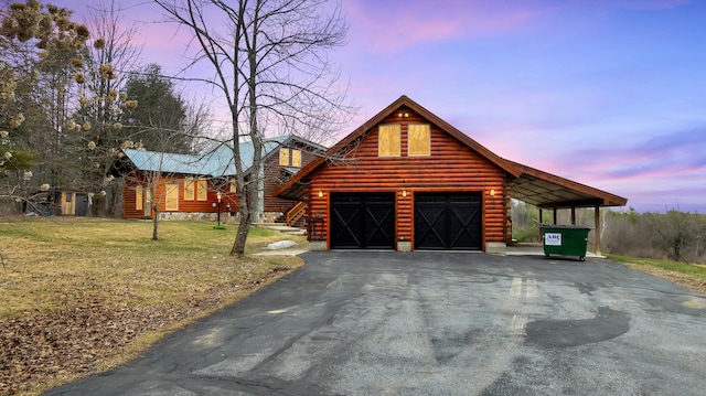 exterior space with a front lawn, log siding, and aphalt driveway