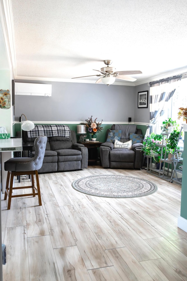 69 Goulds Ridge Rd, Passadumkeag, ME 04475 - living room featuring a textured ceiling, a ceiling fan, crown molding, wood finished floors, and a wall mounted air conditioner