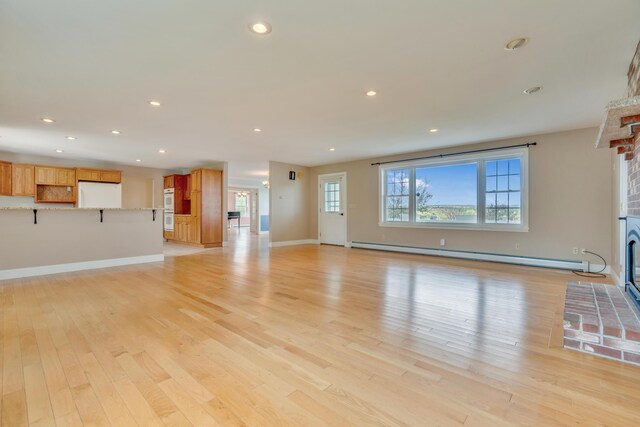 30 Apple Hill Vw, Alfred, ME 04002 - unfurnished living room with a brick fireplace, a baseboard heating unit, light wood-style flooring, baseboards, and recessed lighting