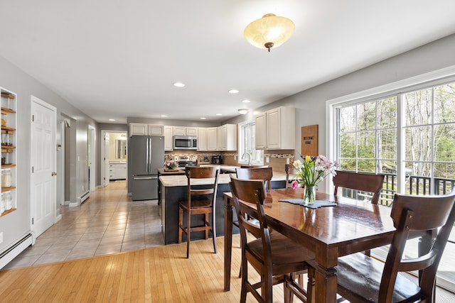 dining area with a baseboard heating unit, recessed lighting, and light tile patterned floors