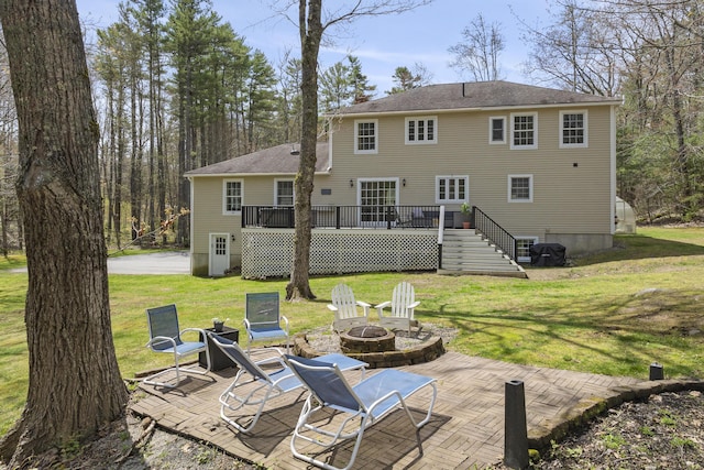 rear view of property with an outdoor fire pit, a patio, a deck, a yard, and stairs
