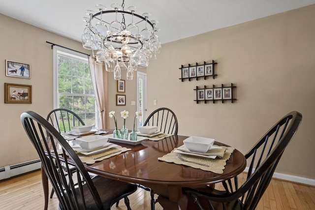 dining area with a chandelier, light wood-style flooring, and baseboards