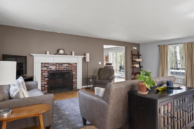 living room with wood finished floors and a brick fireplace