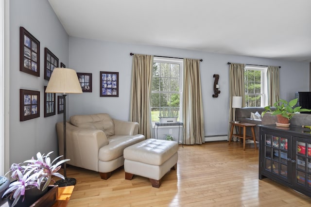 living area with a baseboard radiator and light wood finished floors