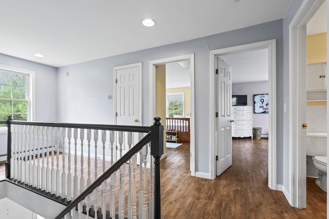 hallway with an upstairs landing, dark wood-type flooring, plenty of natural light, baseboards, and recessed lighting