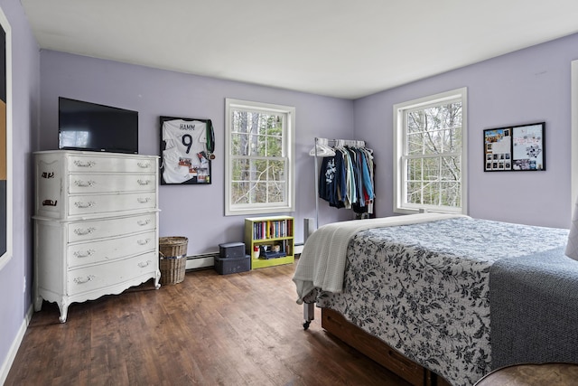 bedroom featuring wood finished floors, a baseboard radiator, and baseboard heating