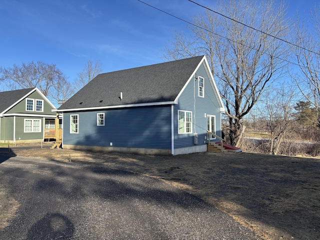 back of house with roof with shingles