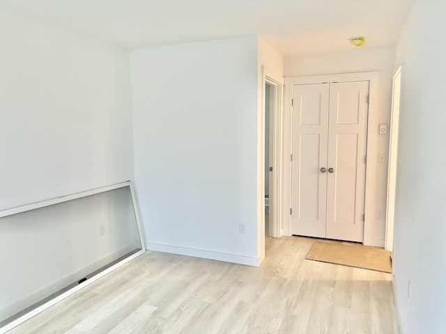 unfurnished room with baseboards and wood finished floors