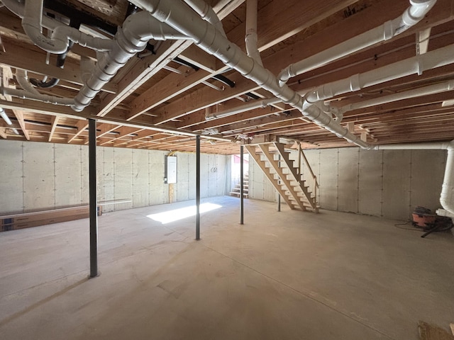 unfinished below grade area with stairway and electric panel