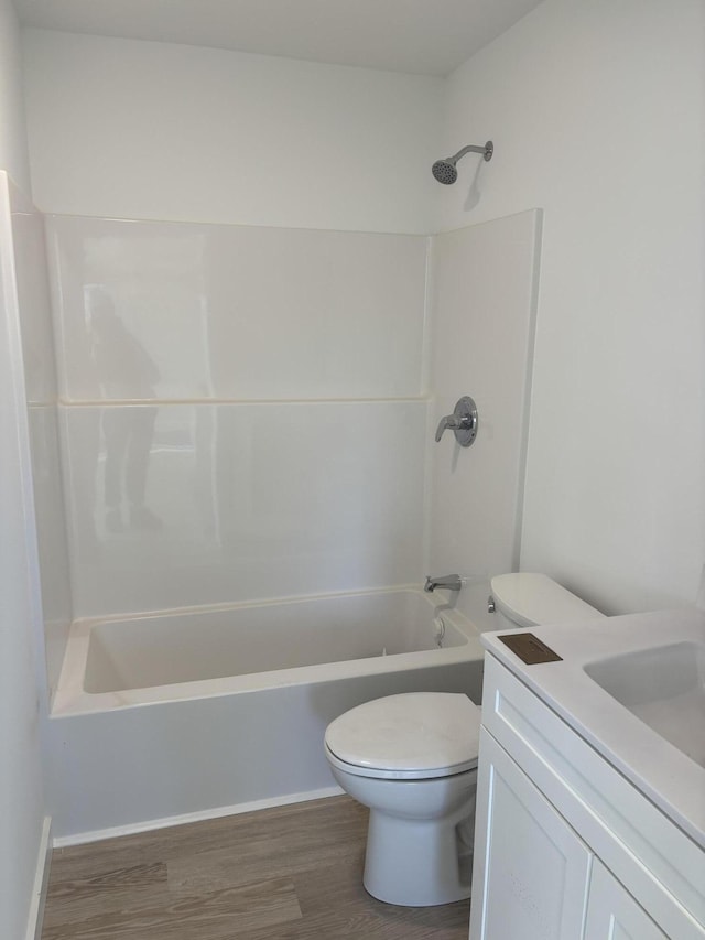 full bath featuring bathing tub / shower combination, wood finished floors, vanity, and toilet