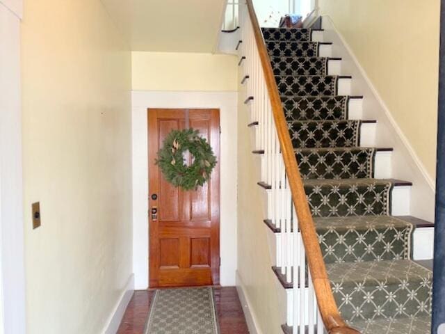 stairs with wood finished floors and baseboards