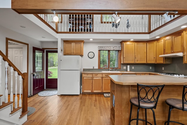 175 Quail Run Rd, Bristol, ME 04539 - kitchen featuring white appliances, a sink, under cabinet range hood, light countertops, and light wood finished floors