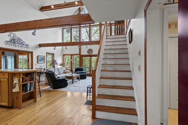 175 Quail Run Rd, Bristol, ME 04539 - stairs featuring track lighting, wood-type flooring, a towering ceiling, and beam ceiling