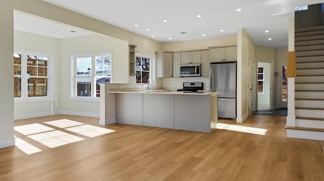 LOT16 Beech St Unit 16, Hallowell, ME 04347 - kitchen featuring stainless steel appliances, light countertops, open shelves, light wood-type flooring, and a peninsula