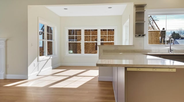 LOT16 Beech St Unit 16, Hallowell, ME 04347 - kitchen with light wood-style flooring, stainless steel dishwasher, a sink, baseboards, and light countertops