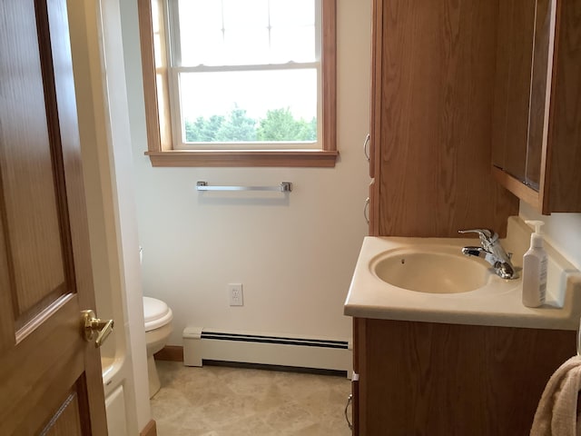 half bathroom with a baseboard heating unit, baseboards, vanity, and toilet