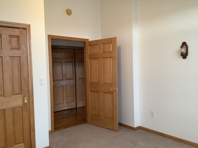 unfurnished bedroom with baseboards and light carpet